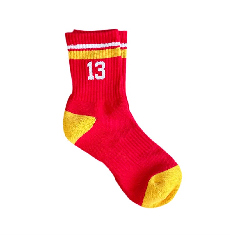May include: Red and yellow striped athletic socks with the number 13 printed in white.