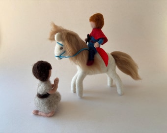 May include: Handmade felt figures depicting a scene with a white horse, a rider in a red cape, and a person kneeling in prayer. The horse has a tan mane and tail, and the rider is wearing blue pants. The kneeling figure is in a gray dress.