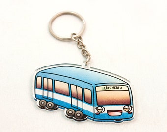 Puede incluir: Un llavero de autobús de dibujos animados azul y blanco con el texto "CÔTE-VERTU" sobre la ventana delantera. El llavero tiene un anillo y una cadena de metal plateado.