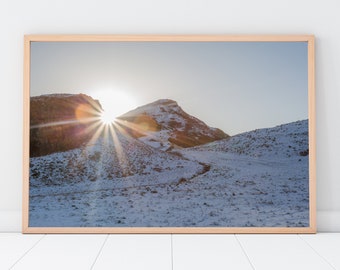 Photographic colour print of the morning sun peeking through behind Arthur's seat in Edinburgh on a cold snowy day