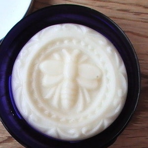 May include: A white soap bar with a butterfly design in a blue and white container.