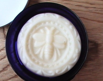 May include: A white soap bar with a butterfly design in a blue and white container.