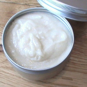 May include: A silver metal container with a white, creamy substance inside. The container has a lid.