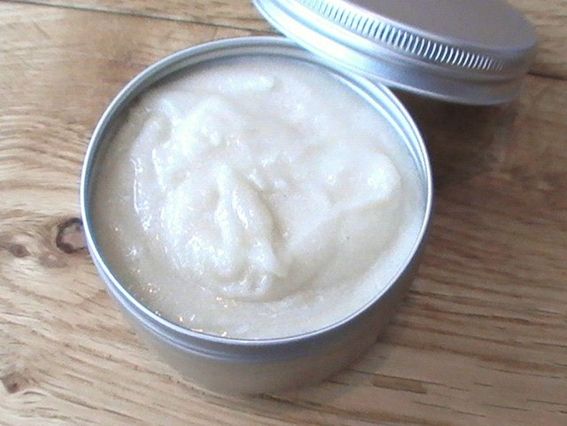 May include: A silver metal container with a white, creamy substance inside. The container has a lid.