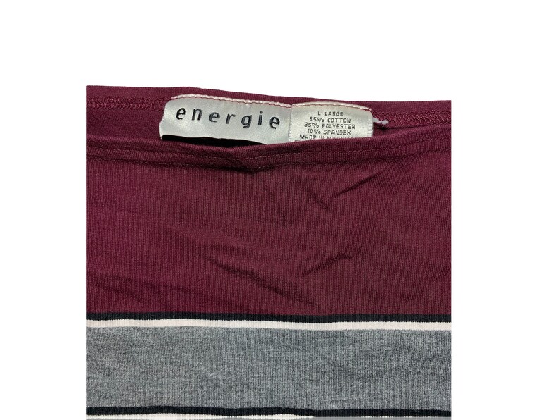 Peut inclure: Un t-shirt ray&eacute; marron et gris avec une &eacute;tiquette blanche qui indique "energie" et "L Large 55% Coton 35% Polyester 10% Spandex Made in Jordan".