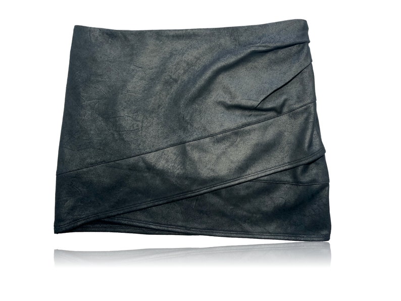 May include: A black faux leather mini skirt with a layered design and a slightly asymmetrical hem.