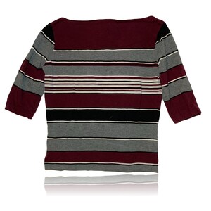 Peut inclure: Un chemisier &agrave; rayures 3/4 avec un motif de couleur marron, gris, noir et blanc.