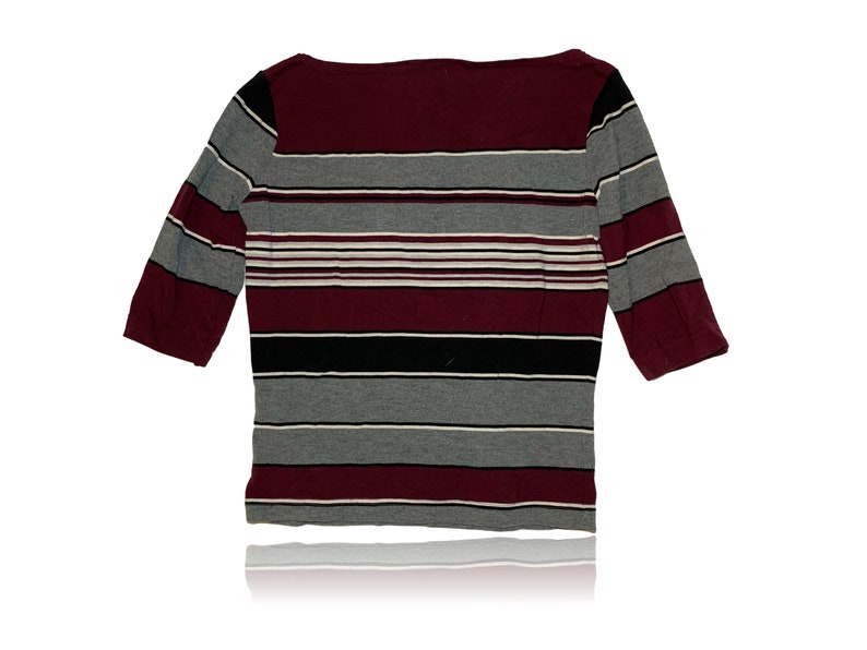Peut inclure: Un chemisier &agrave; rayures 3/4 avec un motif de couleur marron, gris, noir et blanc.