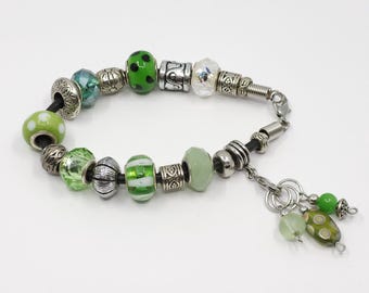 Green/white stitch marker keeper bracelet with Euro-style beads on a black leather cord