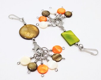 Green or brown shell bead bag charm featuring 6 coordinating shell bead stitch markers