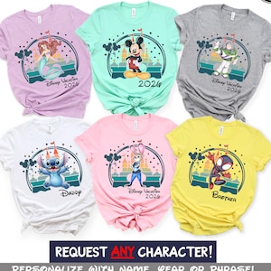 May include: A collection of colorful t-shirts featuring various Disney characters. Each shirt displays a character graphic with the text "Disney Vacation 2026" or "Daddy" or "Brother". The shirts are in shades of pink, yellow, white, gray, and teal.
