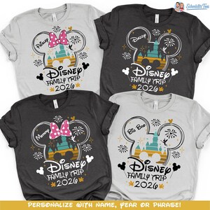 May include: Four t-shirts with a Disney Family Trip 2026 design. Each shirt features a Mickey Mouse head outline with a castle, fireworks, and text. The shirts are in gray, dark gray, and white, with text like "Paisley", "Daddy", "Mommy", and "Big Bro".
