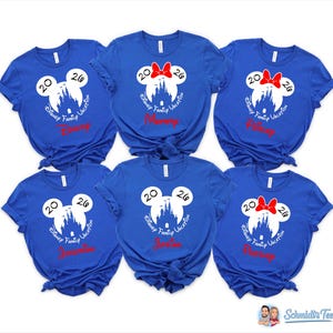 K&ouml;nnte beinhalten: Sechs k&ouml;nigsblaue T-Shirts mit einem wei&szlig;en Mickey Mouse-Kopf-Design, einer Schlosssilhouette und dem Text "Disney Family Vacation 2026". Einige Shirts haben rote Schleifen und Namen wie "Mommy".