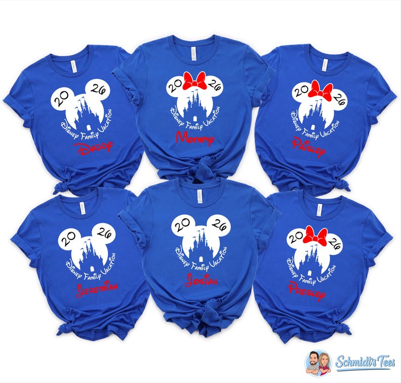 K&ouml;nnte beinhalten: Sechs k&ouml;nigsblaue T-Shirts mit einem wei&szlig;en Mickey Mouse-Kopf-Design, einer Schlosssilhouette und dem Text "Disney Family Vacation 2026". Einige Shirts haben rote Schleifen und Namen wie "Mommy".