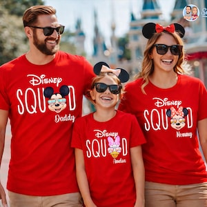 May include: Red t-shirts with the text "Disney Squad" and Mickey and Minnie Mouse graphics. The shirts are worn by a family, with the text "Daddy", "Mommy", and a name on each shirt. The family is wearing sunglasses and mouse ears.
