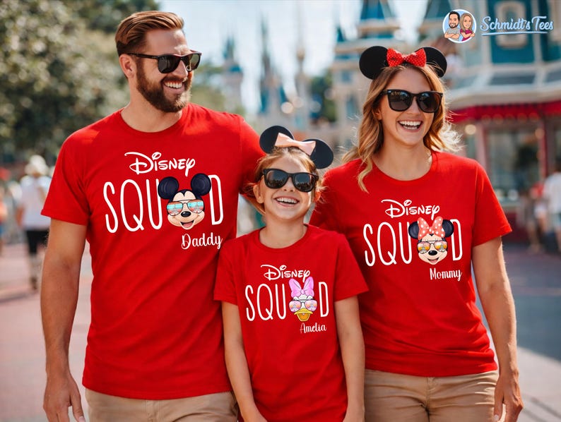 May include: Red t-shirts with the text "Disney Squad" and Mickey and Minnie Mouse graphics. The shirts are worn by a family, with the text "Daddy", "Mommy", and a name on each shirt. The family is wearing sunglasses and mouse ears.