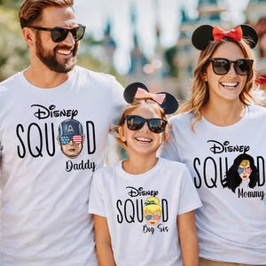 May include: White t-shirts with the text "Disney Squad" and character graphics. The shirts feature "Daddy", "Mommy", and "Big Sis" designations. The characters are Captain America, Wonder Woman, and Tinkerbell.