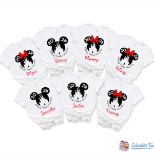 Puede incluir: Seis camisetas blancas de manga corta con una silueta negra de orejas de Mickey con un castillo blanco dentro, el texto 2026 y Disney Family Vacation. Cada camiseta muestra un nombre rojo &uacute;nico: Piper, Daddy, Mommy, Paisley, Jeremiah, Josiah, Presley.