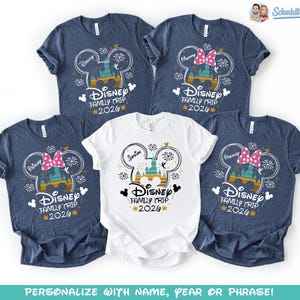 May include: Five short-sleeved t-shirts. Four are navy blue, and one is white. Each shirt features a Disney-themed graphic with the text "Disney Family Trip 2026". Some shirts have names like "Daddy" and "Mommy".