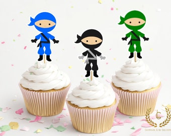 May include: Three cupcakes with white frosting, each topped with a ninja-themed decoration. The ninjas are in blue, black, and green outfits. The cupcake liners are pink.