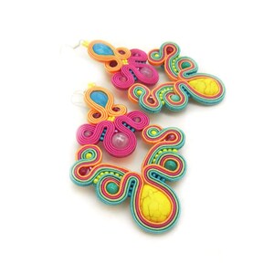 Pu&ograve; includere: Un paio di orecchini colorati con un design turchese, rosa, giallo e arancione. Gli orecchini presentano una variet&agrave; di perline e pietre.