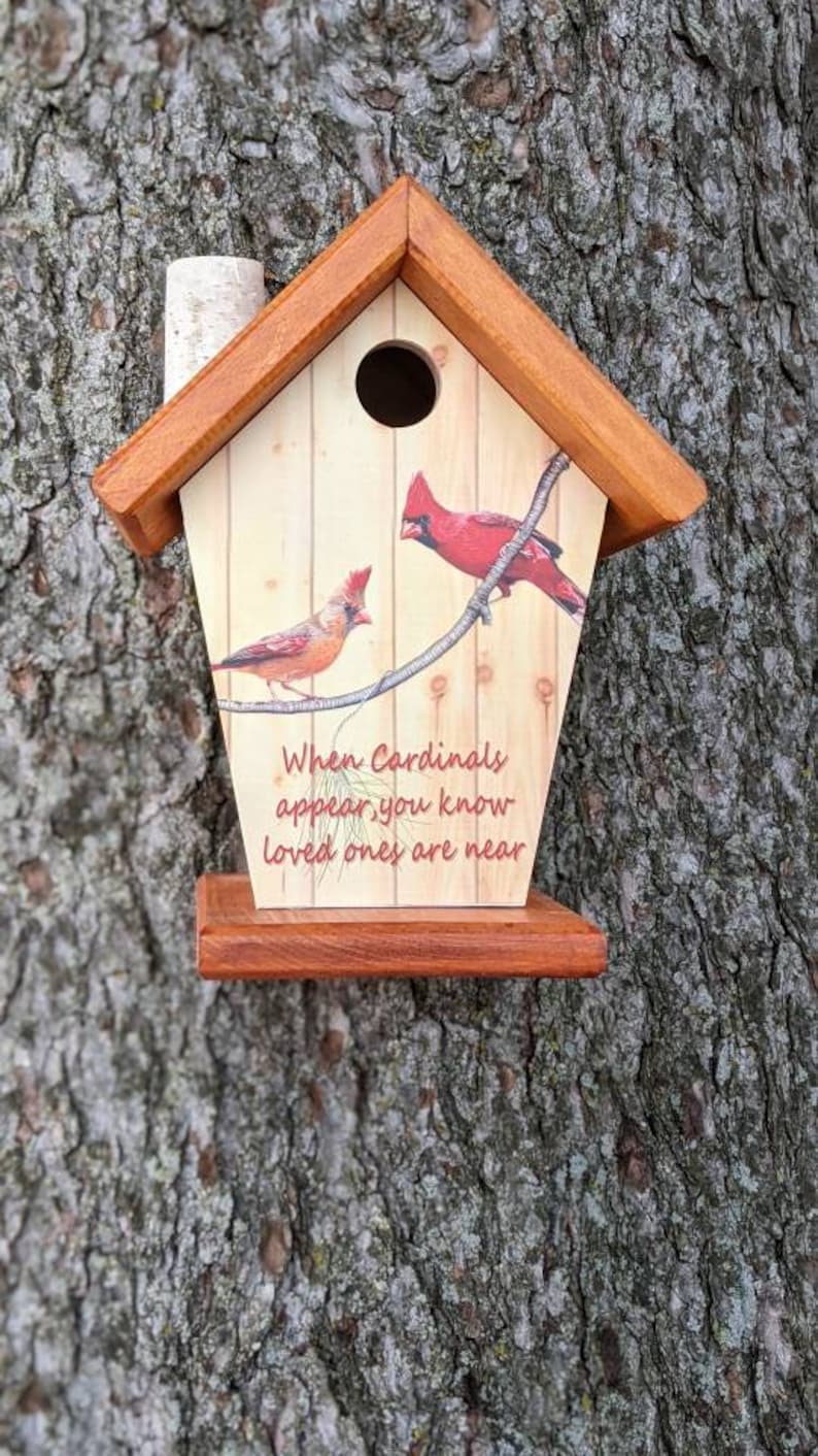 May include: Wooden birdhouse with a pitched roof and a small chimney. The front features a painted design of two red cardinals perched on a branch, with the text "When Cardinals appear, you know loved ones are near."