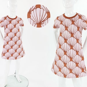 Könnte beinhalten: Ein kurzärmliges Kleid in Rosa und Braun mit einem Muschelmuster. Das Kleid hat einen runden Ausschnitt und einen leicht ausgestellten Rock.