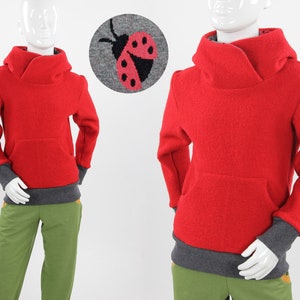 Könnte beinhalten: Roter Kapuzenpullover mit Kängurutasche und grauen Abschlüssen. Der Pullover ist aus einem weichen, flauschigen Material.