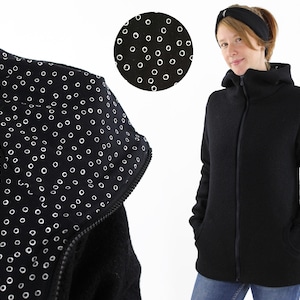 May include: Black hooded jacket with a zipper closure and a white polka dot pattern on the inside of the hood.