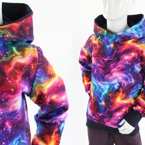 Könnte beinhalten: Ein schwarzer Kapuzenpullover mit einem bunten Galaxie-Druck. Der Druck zeigt wirbelnde Nebel in den Farben Pink, Blau, Orange und Gelb vor einem dunkelvioletten Hintergrund.