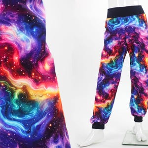 Può includere: Pantaloni con stampa galassia in un vivace mix di colori, tra cui viola, blu, rosso e giallo. I pantaloni hanno vita e polsini neri. Il tessuto mostra un design a nebulosa vorticosa, creando un'estetica cosmica.