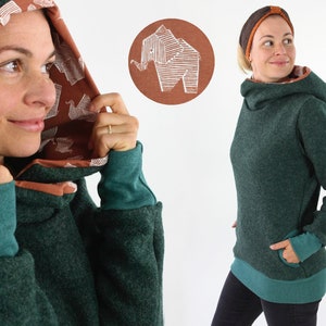 Peut inclure: Un sweat-shirt à capuche vert avec une doublure turquoise et un tissu turquoise contrastant sur les poignets et l'ourlet inférieur. La capuche est doublée d'un motif brun et blanc.