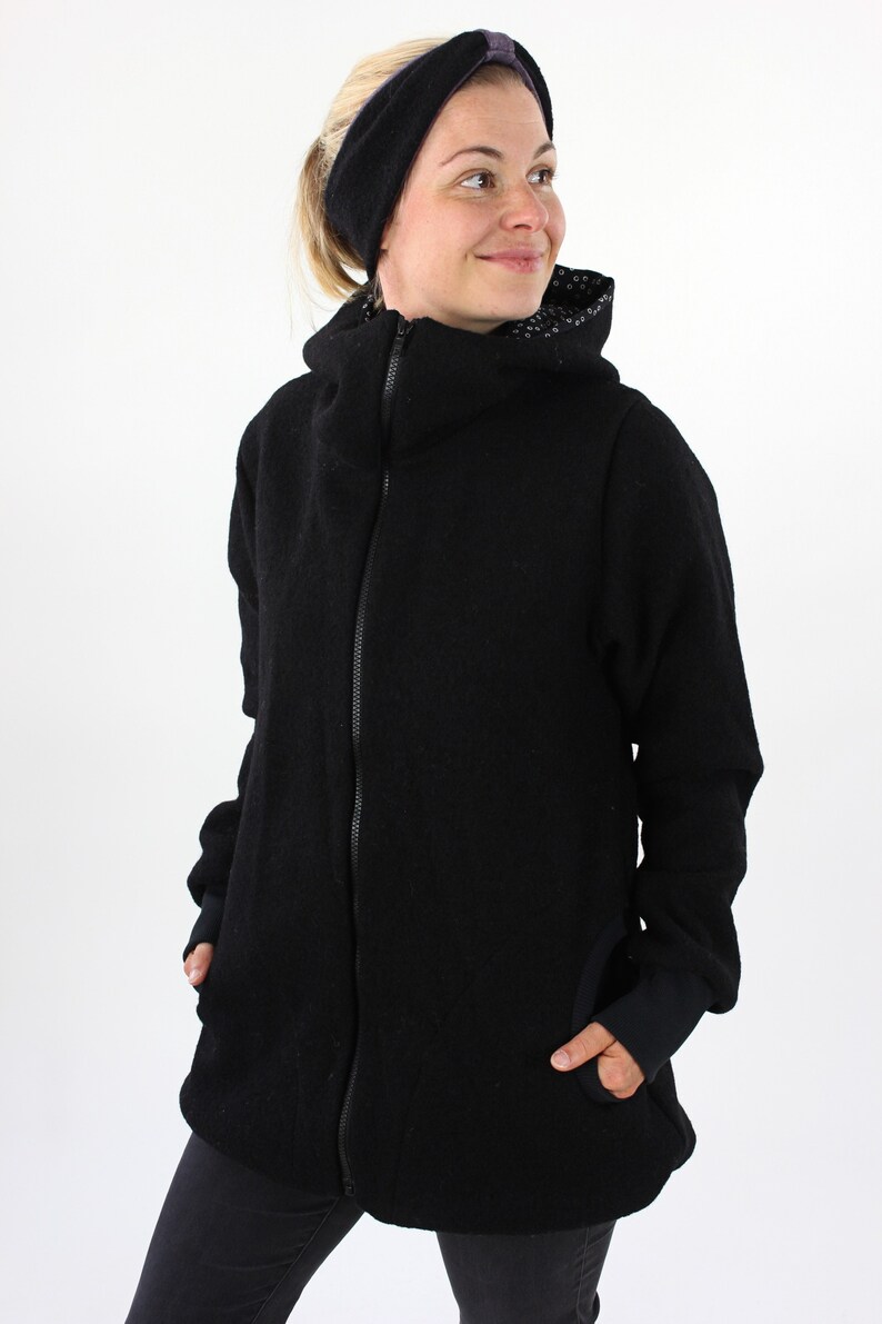 May include: A black zip-up jacket with a high collar and a black and white patterned lining. The jacket has a relaxed fit and is made of a soft, comfortable fabric.