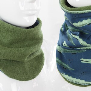 Könnte beinhalten: Zwei Halstücher, eines ist aus grünem Fleece und das andere ist blau mit einem grünen Alligator-Druck.