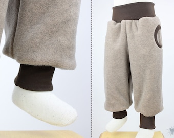 Tobehose aus beige meliertem Öko-Fleece, mit Taschen, wächst lange mit, kuschelweich, wärmespeichernd und wasserabweisend