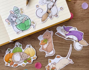 Könnte beinhalten: Fünf süße Mausaufkleber mit verschiedenen Themen. Eine Maus trägt einen Hexenhut und hält einen Besen, eine andere hält eine Flasche mit Zaubertrank, eine schläft auf einem Haufen Kürbisse und Blättern, und zwei halten Blätter.