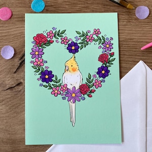 Coeur de fleur de calopsitte | Carte de voeux vierge | Calopsitte mignonne se reposant dans un coeur de carte de Zazzle.be Liste d'envies Vous avez des idées ? Carte de voeux mignon oiseau de compagnie Tiel