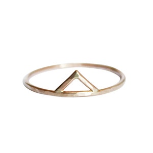 Thin gold ring with the outline of a triangle or a spike shape on one side of the ring. Slight hammered texture.