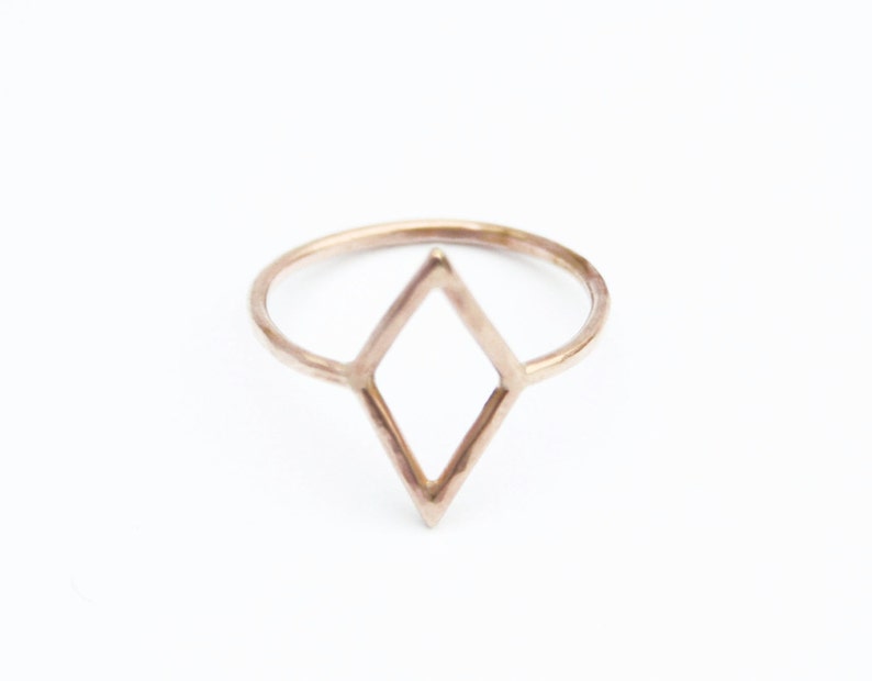 Very thin wire creating the outline of a diamond shape with thin wire as the ring band. Shown in gold tone with a light hammered finish.