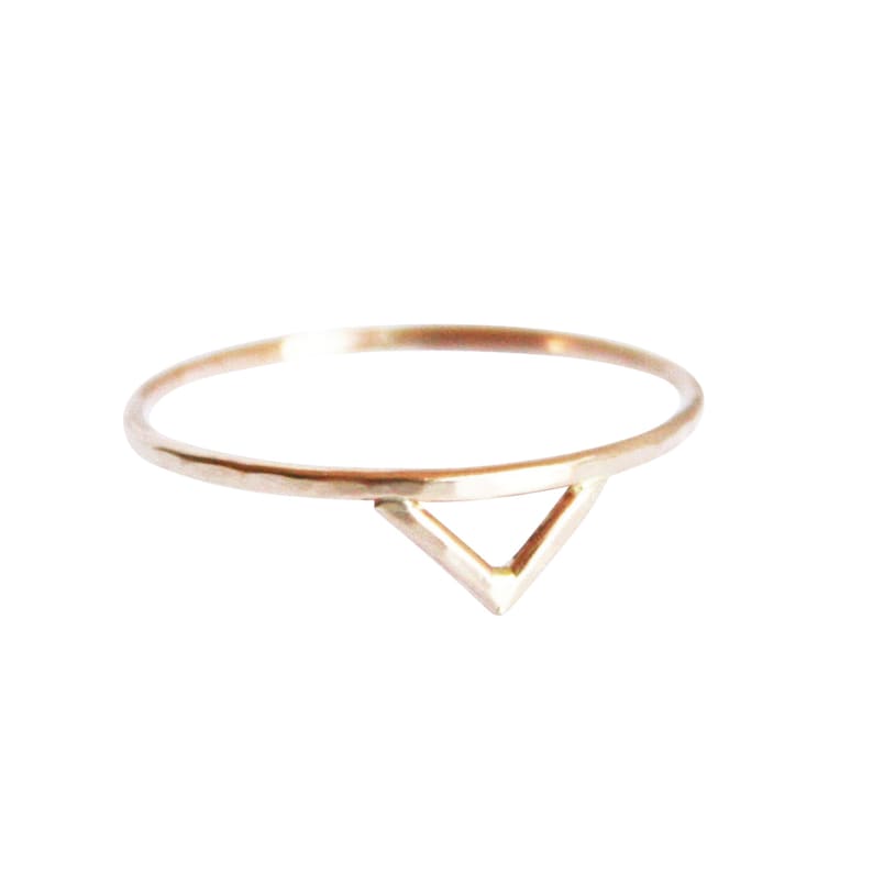 Thin gold ring with the outline of a triangle or a spike shape on one side of the ring. Slight hammered texture.