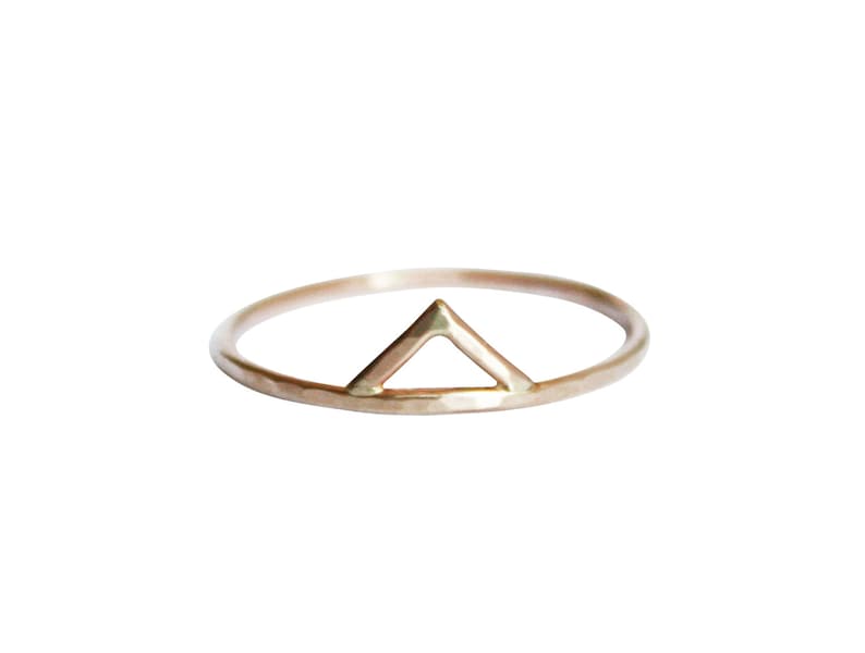 Thin gold ring with the outline of a triangle or a spike shape on one side of the ring. Slight hammered texture.