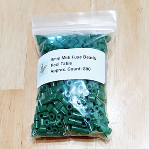 May include: A clear plastic bag filled with dark green 5mm Midi Fuse Beads. The label reads "5mm Midi Fuse Beads Pool Table Approx. Count: 800". The beads are cylindrical and are used for crafting and creating pixel art.