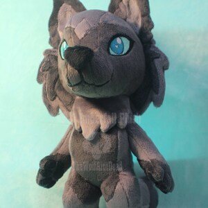 May include: A gray plush wolf with blue eyes. The wolf is standing on a light blue surface.