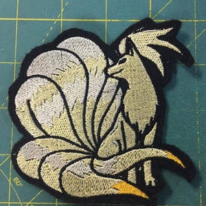 Peut inclure: Patch brodé représentant un renard à neuf queues blanc et jaune, un personnage populaire de la franchise Pokémon.