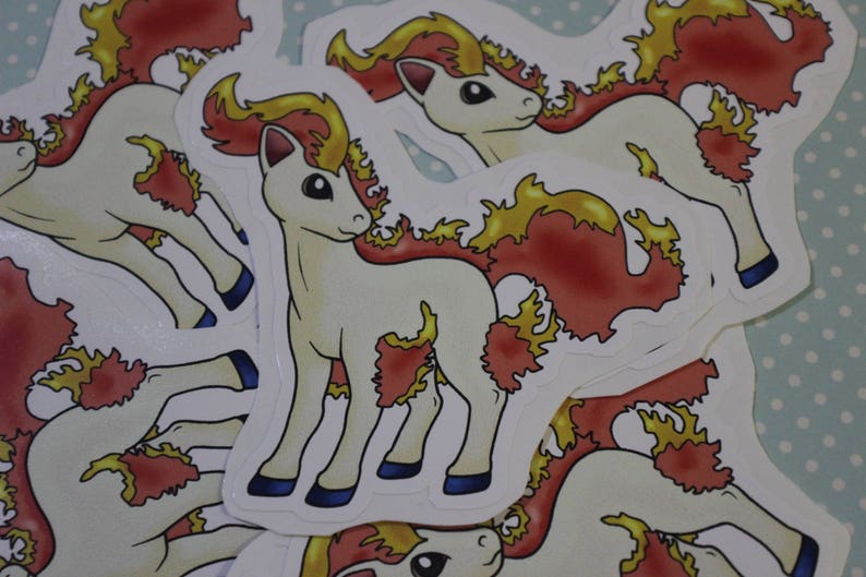 May include: A stack of white and red cartoon stickers featuring a horse-like creature with a mane of flames. The creature has a white body with red and yellow flames around its body.