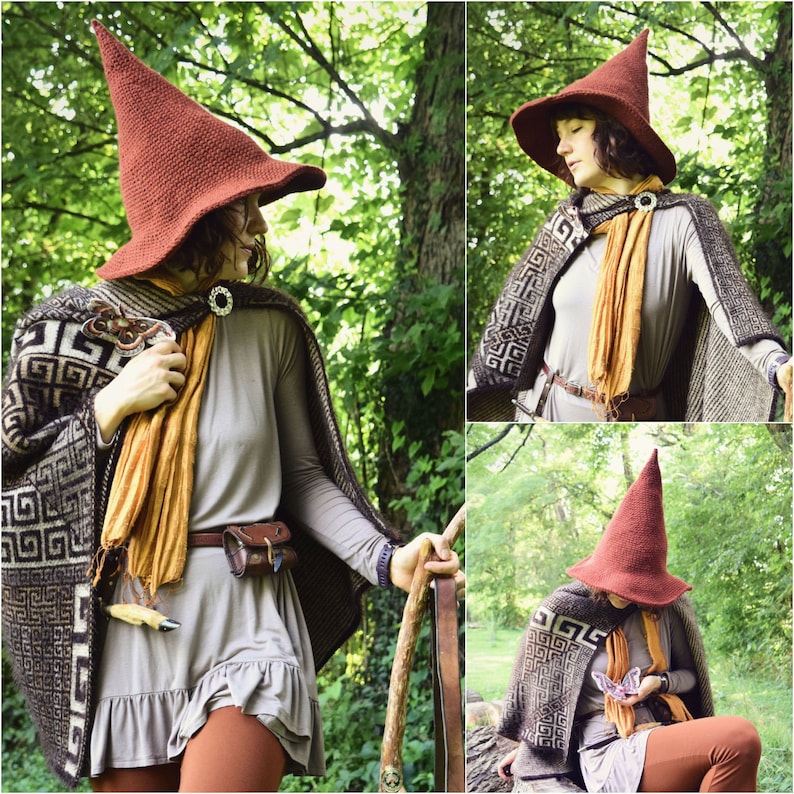May include: A woman wearing a brown pointed hat with a brown and white patterned cape. She is holding a staff in her hand and is standing in a forest.