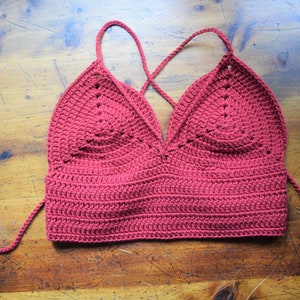 May include: A red crocheted halter top with a criss-cross back and long ties.