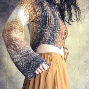 May include: A brown, white, and black ombre knit sweater with a lace-up front and long sleeves. The sweater is cropped and has a relaxed fit.