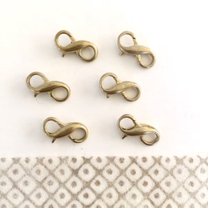 May include: Six gold-toned metal infinity lobster clasps. These clasps are perfect for jewelry making and can be used to create necklaces, bracelets, and other accessories.