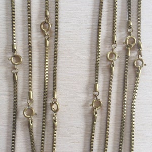 May include: Five gold chain necklaces of varying lengths, all with lobster claw clasps.
